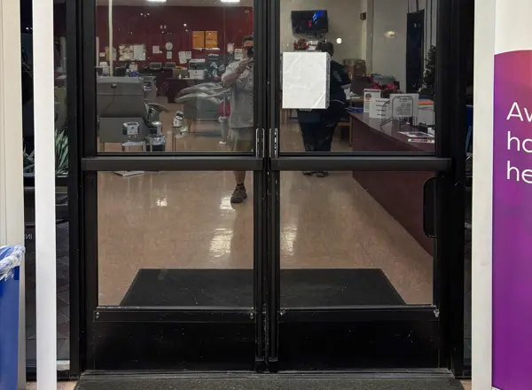 Commercial glass storefront doors with exit panic bar hardware installed by Mattlock in Las Vegas