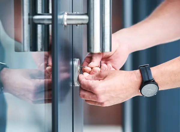 A locksmith picking the front entrance of a commercial building